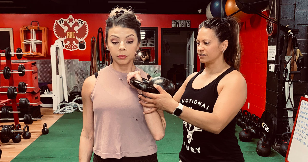 Jessica Pino Coaching kettlebell client at her gym