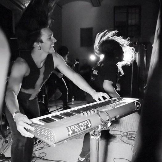 Sam Hartman on stage with his band playing keyboard